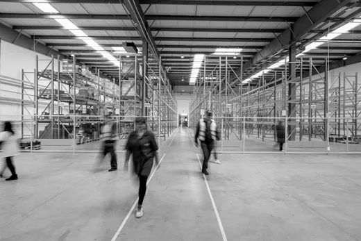 Two workers walking a warehouse aisle