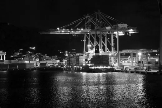 Gantry cranes lit against a night sky at a container terminal