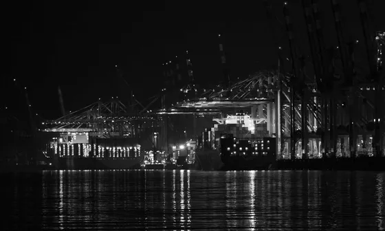 Port cranes reflected in still water at night